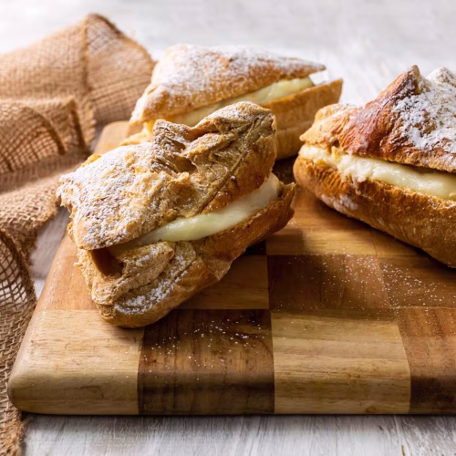 Pañuelos | Pastelería Ciro Guatemala | Suaves cuadros de hojaldre horneado con mantequilla que se doblan como un pañuelo para abrazar un relleno cremoso de manjar de leche. Terminados con azúcar glas, son piezas delicadas que combinan elegancia visual con sabor genuino.