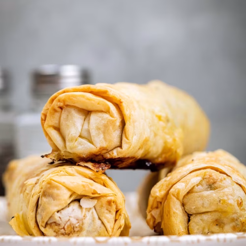 Rollo de carne encebollada | Pastelería Ciro Guatemala | Crujientes láminas de masa filo envolviendo un jugoso relleno de carne de res salteada con cebolla caramelizada y especias. Una combinación de texturas — crujiente por fuera, suave y sabrosa por dentro — que refleja la técnica artesanal mediterránea.