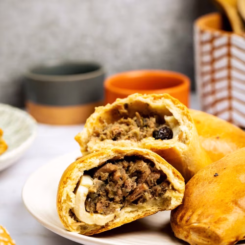 Empanada chilena | Pastelería Ciro Guatemala | Fiel a la receta chilena tradicional: masa horneada crujiente rellena de carne de res molida sazonada, trozos de huevo duro y pasas que aportan un dulzor sutil. Un balance de sabores que lleva décadas siendo parte de la pastelería latinoamericana de calidad.