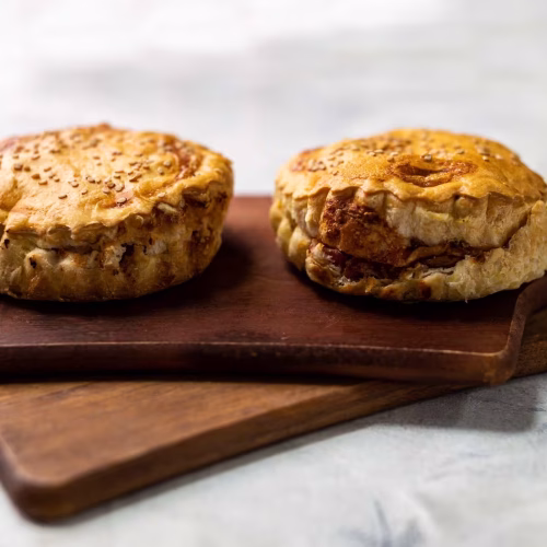 Pie jamón y queso | Pastelería Ciro Guatemala | Porción individual de hojaldre horneado con mantequilla, crujiente y dorado, relleno generosamente de jamón y queso crema suave. Una opción salada perfecta para un desayuno especial o merienda con carácter.