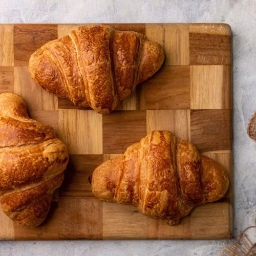 Croissant jamón y queso | Pastelería Ciro Guatemala | Croissant artesanal de masa laminada con mantequilla importada, dorado y crujiente por fuera con capas aireadas por dentro, relleno de jamón de pavo seleccionado y queso chédar fundido. Un croissant salado que es al mismo tiempo sustancioso y refinado.