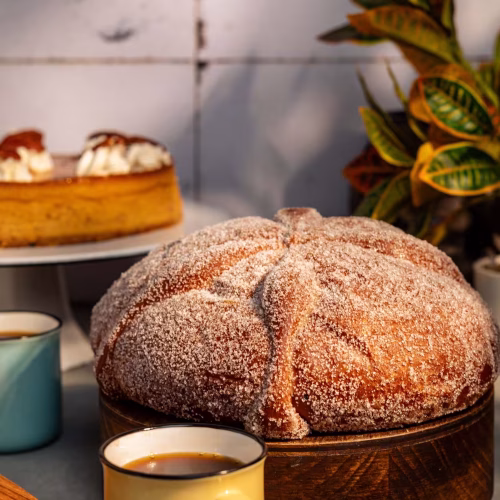 Pan de Muerto | Pastelería Ciro Guatemala | Tradicional y lleno de sabor, nuestro pan de muerto está elaborado con una suave masa enriquecida con mantequilla sin sal que le brinda una textura esponjosa y delicada. La esencia de naranja aporta un aroma caracteristico y un toque cítrico que realza su sabor único. Ideal para disfrutar en cualquier ocasión, es un clásico que combina tradición y calidad.