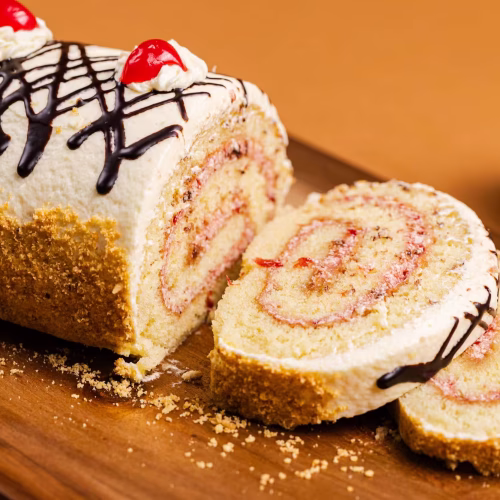 Brazo de Vainilla | Pastelería Ciro Guatemala | Clásico brazo gitano de bizcocho de vainilla suave, relleno con mermelada de fresa y cubierto de crema de vainilla. Una pieza de pastelería clásica y reconfortante que nunca decepciona.