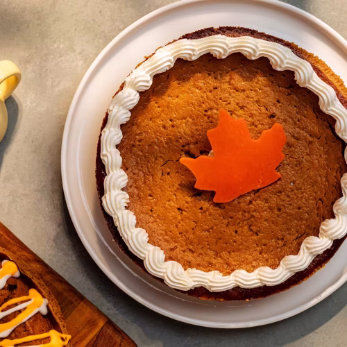 Pie de calabaza | Pastelería Ciro Guatemala | Pie de base crujiente de galleta con relleno de calabaza suave y especiada, coronado con un copete de crema batida. Un clásico de temporada preparado con calabaza fresca que resulta en un postre cálido, dulce y reconfortante.
