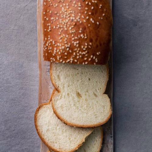 Pan de molde | Pastelería Ciro Guatemala | Pan de molde artesanal de miga suave y uniforme, horneado en casa con masa fermentada lentamente y cubierto de semillas de ajonjolí. Una alternativa artesanal al pan industrial que se nota desde el primer bocado.